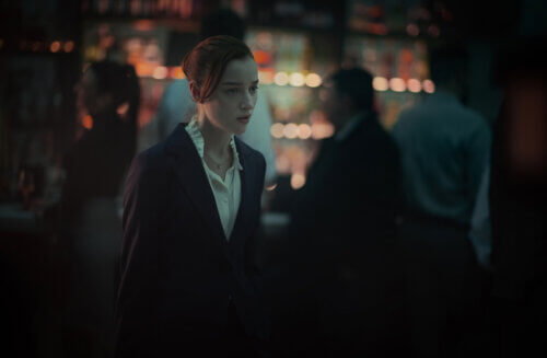 Phoebe Dynevor in a suit walking looking nervious.