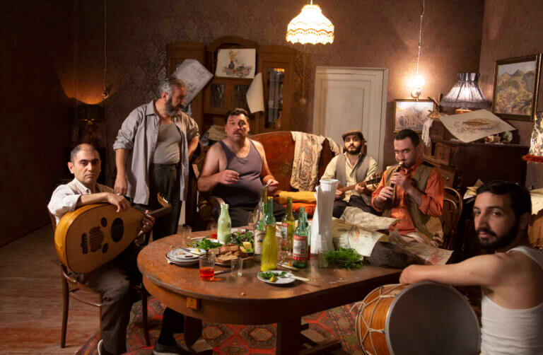 Men in an apartment hanging out and drinking.