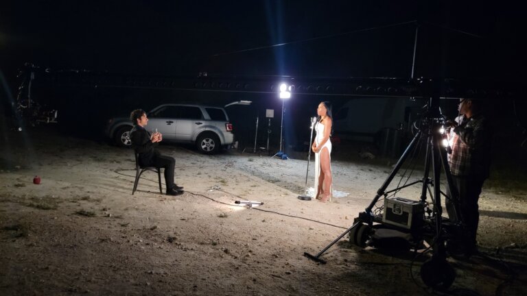 Bella Cruz and her fellow actor filming a project on a beach at night.