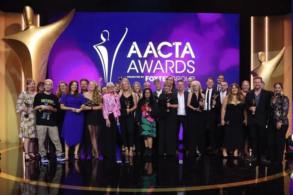 Casting directors assembled on stage smiling.