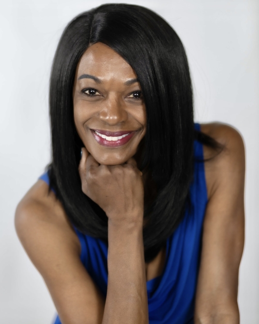 Actor Andrea Robinson in a blue shirt smiling.