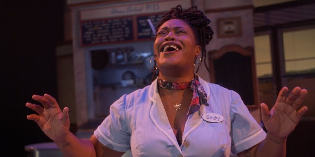 Charity Dawson in a waitress uniform smiling.