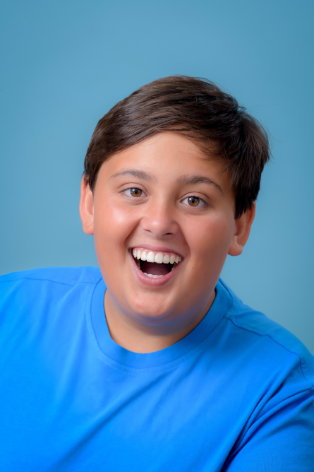 Actor Charles Suleman in a blue shirt smiling.