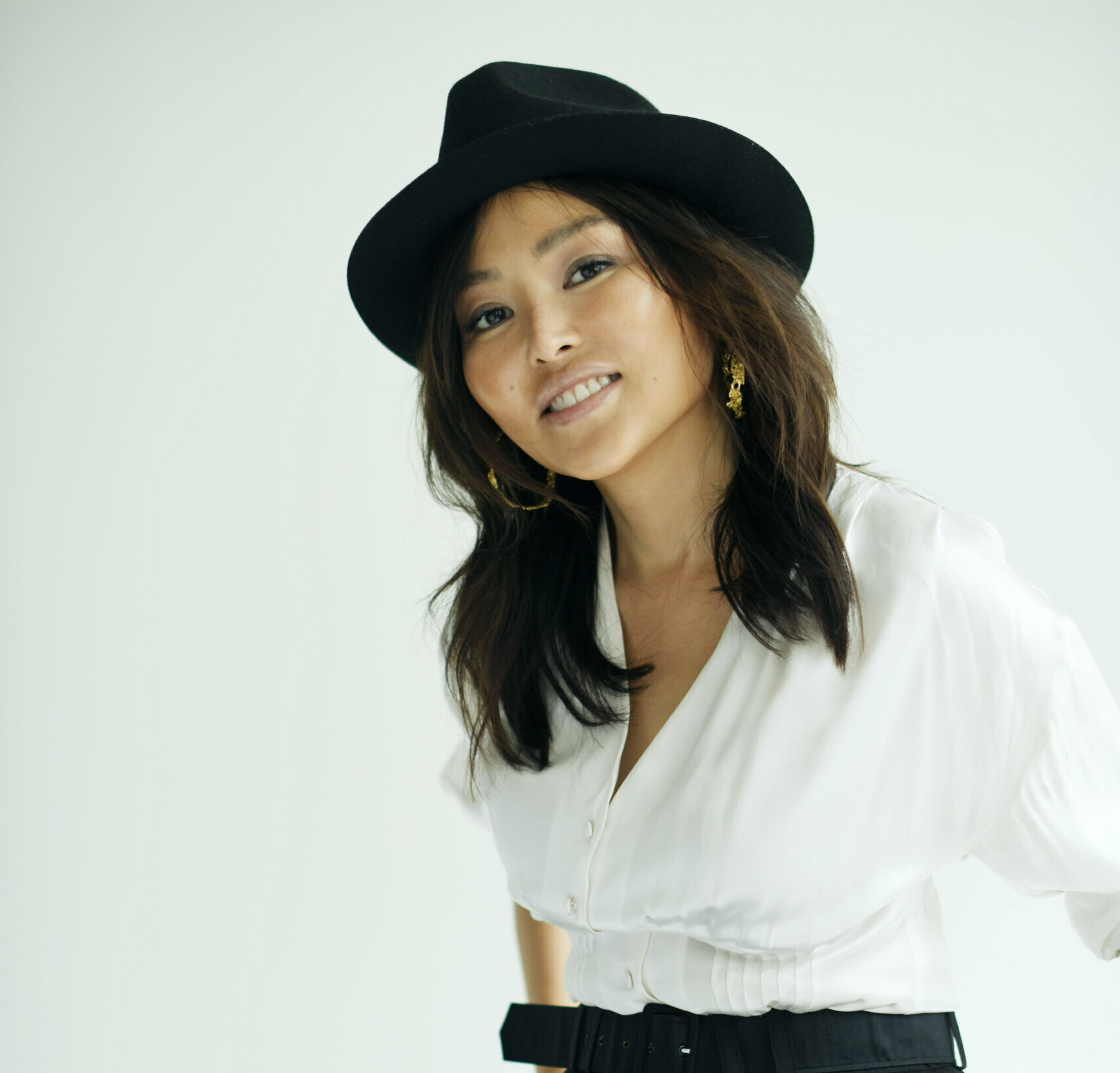 Elizabeth Tan sitting in a chair with a hat and looking cool.