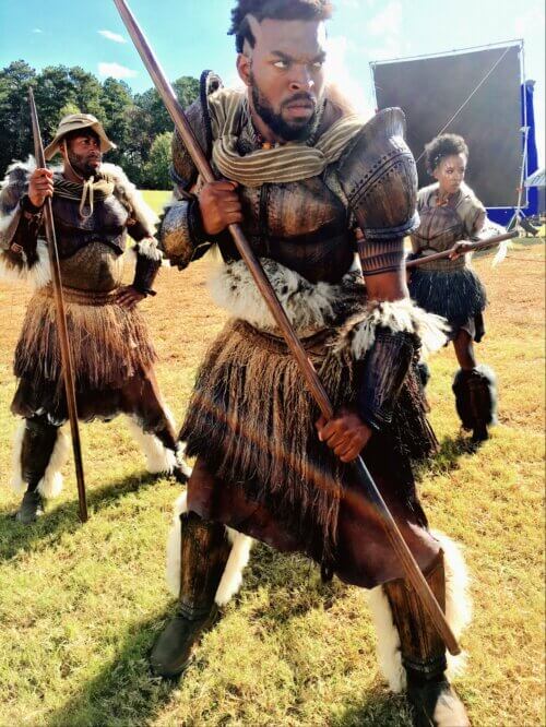 Mark Willis and other actors in costume on the set of Black Panther.