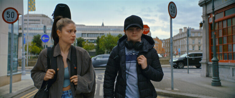 Eve Hewson and Orén Kinlan walking through the city.