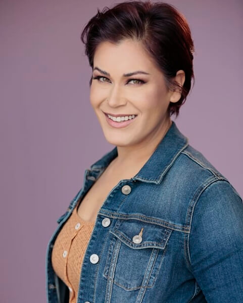 Actor Heather Cross in a denim jacket smiling.