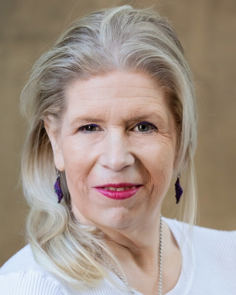 Actor Lisa Lauenberg smiling in a white shirt.