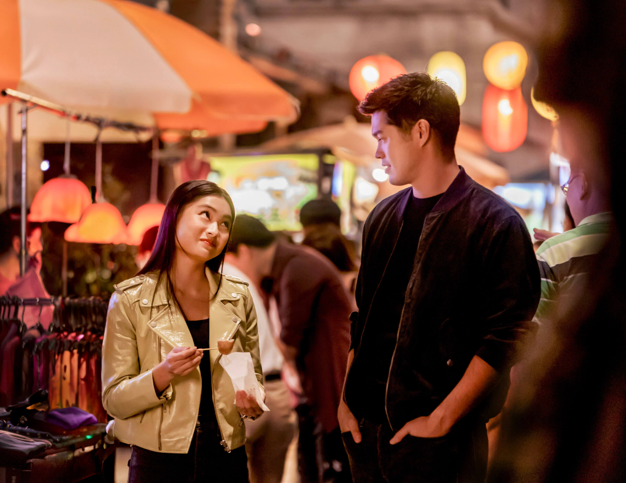 Actors Ashley Liao and Ross Butler walking in the street talking.