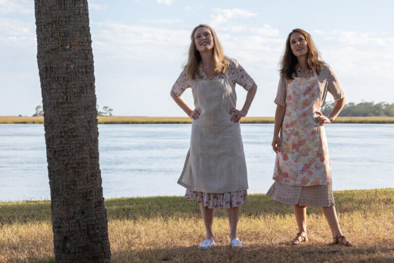 Natalie Portman and Julianne Moore looking outside by a river.