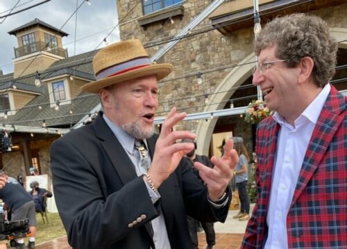 Actors Dan Jablons and Michael Rooker hanging out on set wearing suits.