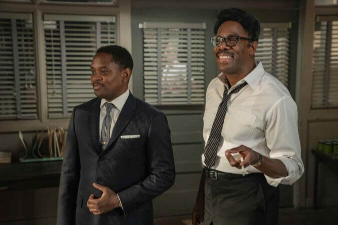 Colman Domingo and Aml Ameen smiling and talking in an office