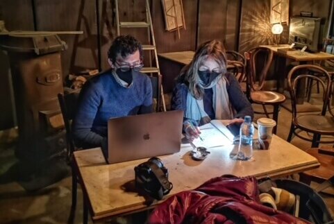 Director Joshua Salzberg and Shira Piven working on a laptop on set wearing masks.