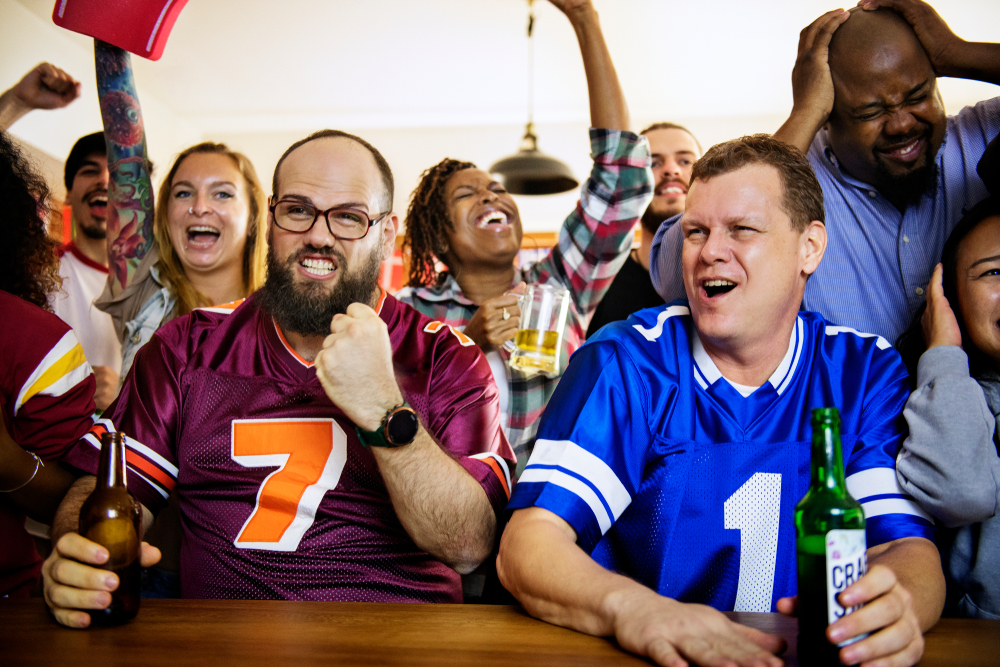 Diverse group of friends at a bar watching footbal.