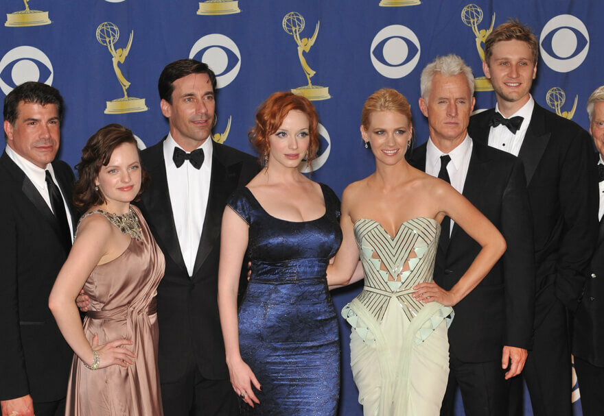 The cast of Mad Men in fancy tuxedos and dresses for an award show.