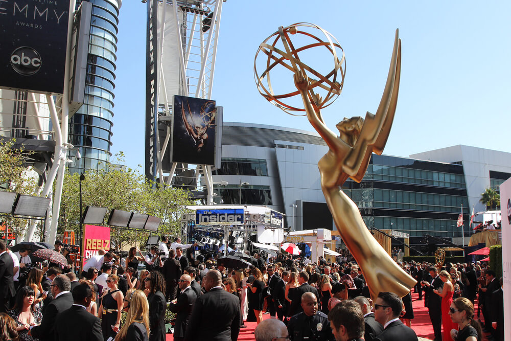 Giant Emmy statue in front of a large group of celebrities.