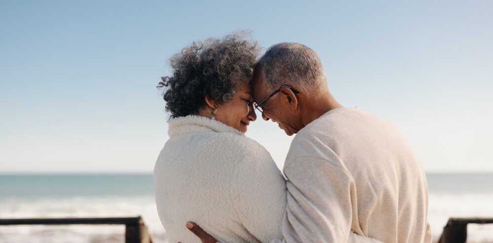 Older African American couple sharing a romantic moment on the beach.