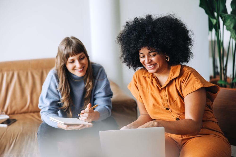 two women watching something on a laptop