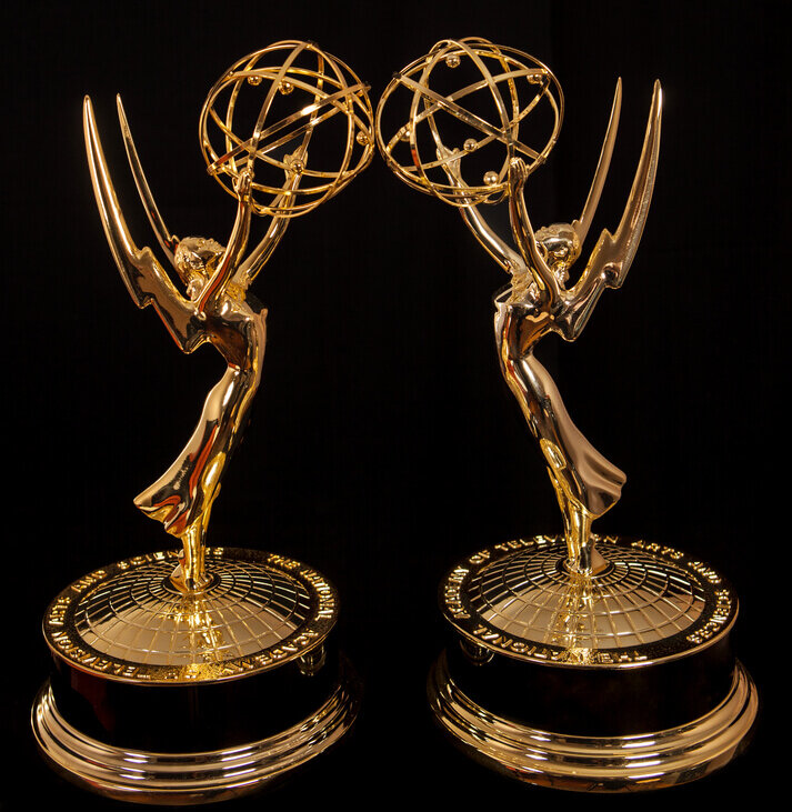 Two Emmy statues side by side.