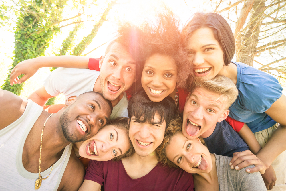 Diverse group of friends smiling and posing for a selfie.