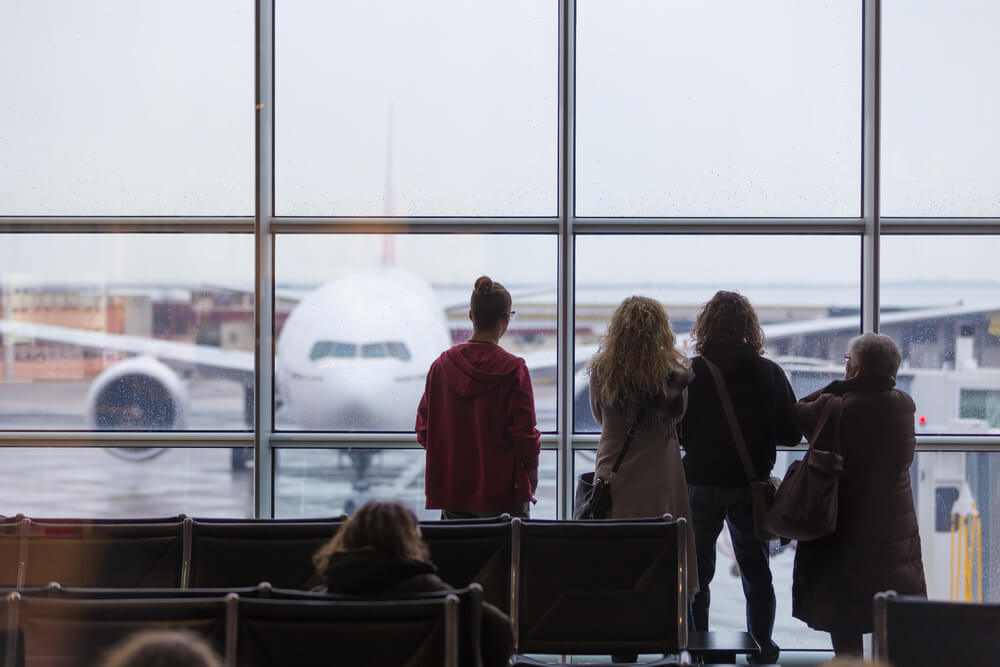 Four women of varying ages stuck at an airport staring at a plane.