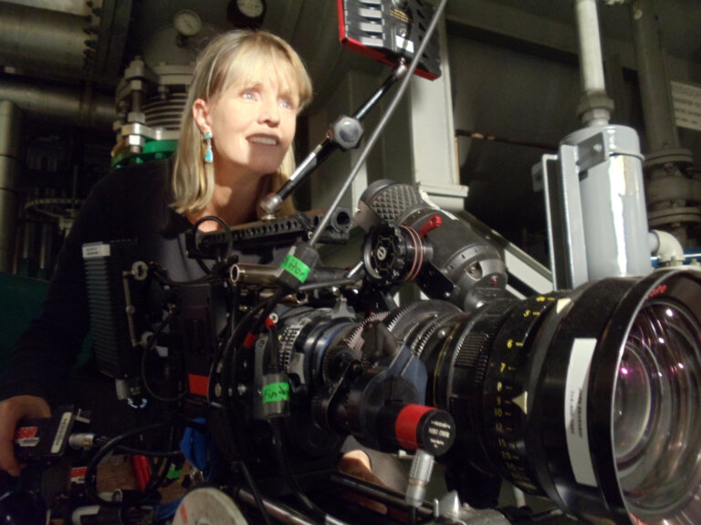 Producer Kelli Lessie filming with a huge camera.