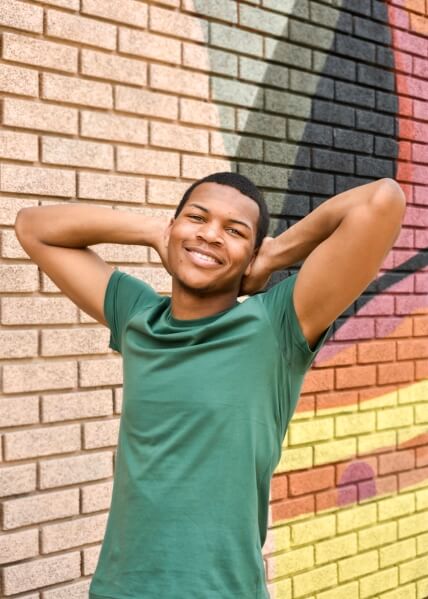 Actor Tarren Knox smiling in a green shirt outside.