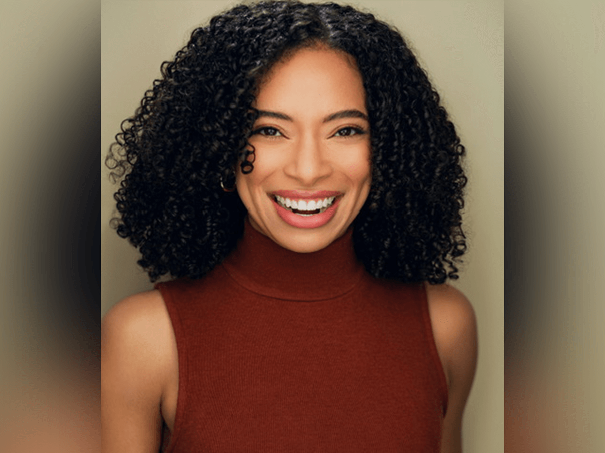 Actor Ashlei Hazell smiling in a sleveless burgundy turtleneck