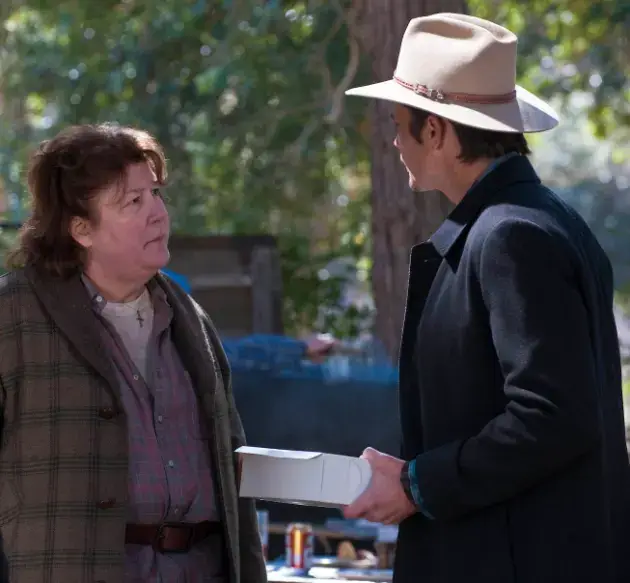 Margo Martindale and Timothy Olyphant outside arguing.