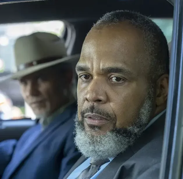 Victor Williams and Timothy Olyphant sitting in a car.